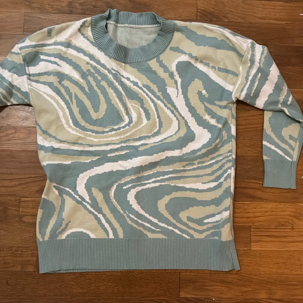 Green and blue swirl patterned sweater.